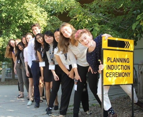 students in the line with induction ceremony sign