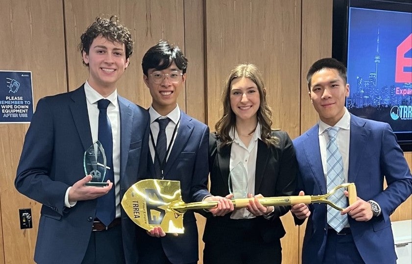 The four students holding a glass award and a golden shovel award.