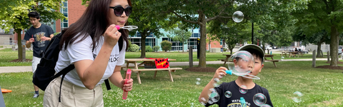 Mother and son blowing bubbles at postdoc outdoor games event
