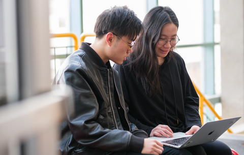 Two people looking at a laptop
