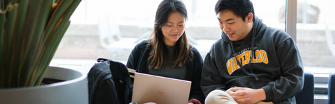 Two people looking at a laptop