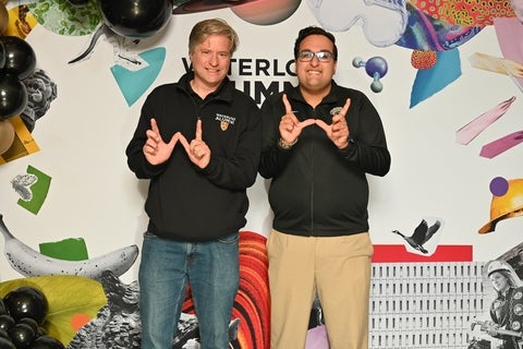 Bill and the WUSA president making the W sign with their hands for waterloo 