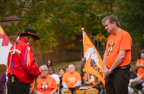 Bill in an orange shirt representing  residential school trauma, along with Indigenous elder Henry