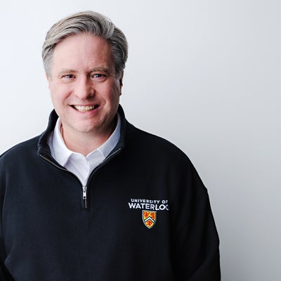 Dr. Rosehart smiling, wearing a UWaterloo quarter-zip sweater