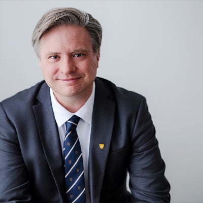 Dr. Rosehart in a suit sitting