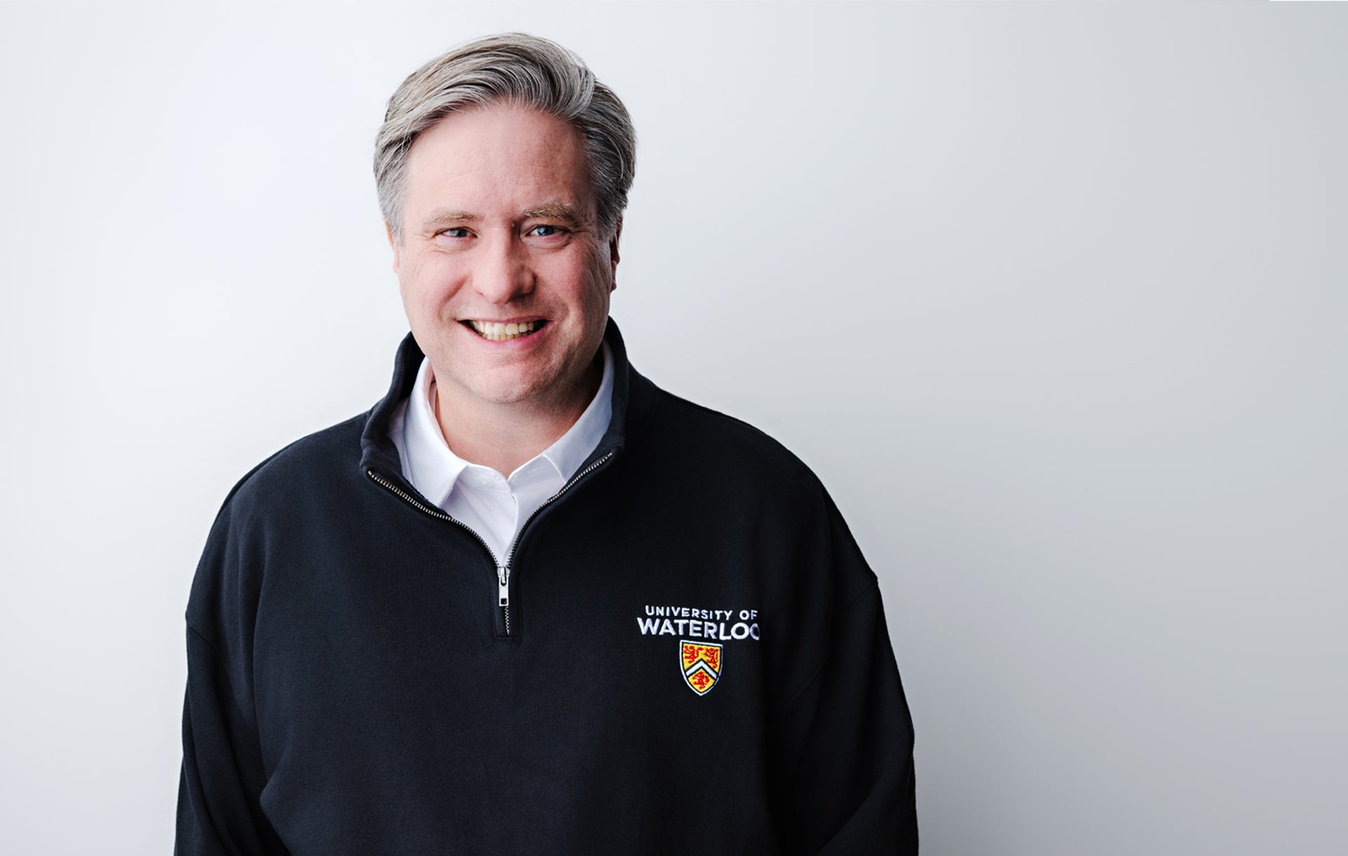 Dr. Rosehart smiling, wearing a UWaterloo quarter-zip sweater