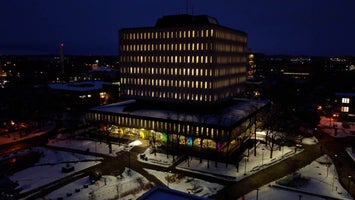 Aerial of Dana Porter illuminated with multi-coloured lights with snow on the ground