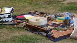 Indigenous ceremonial materials are laid out on blanket including a drum 
