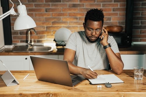 man at a table sitting in front of a computer.