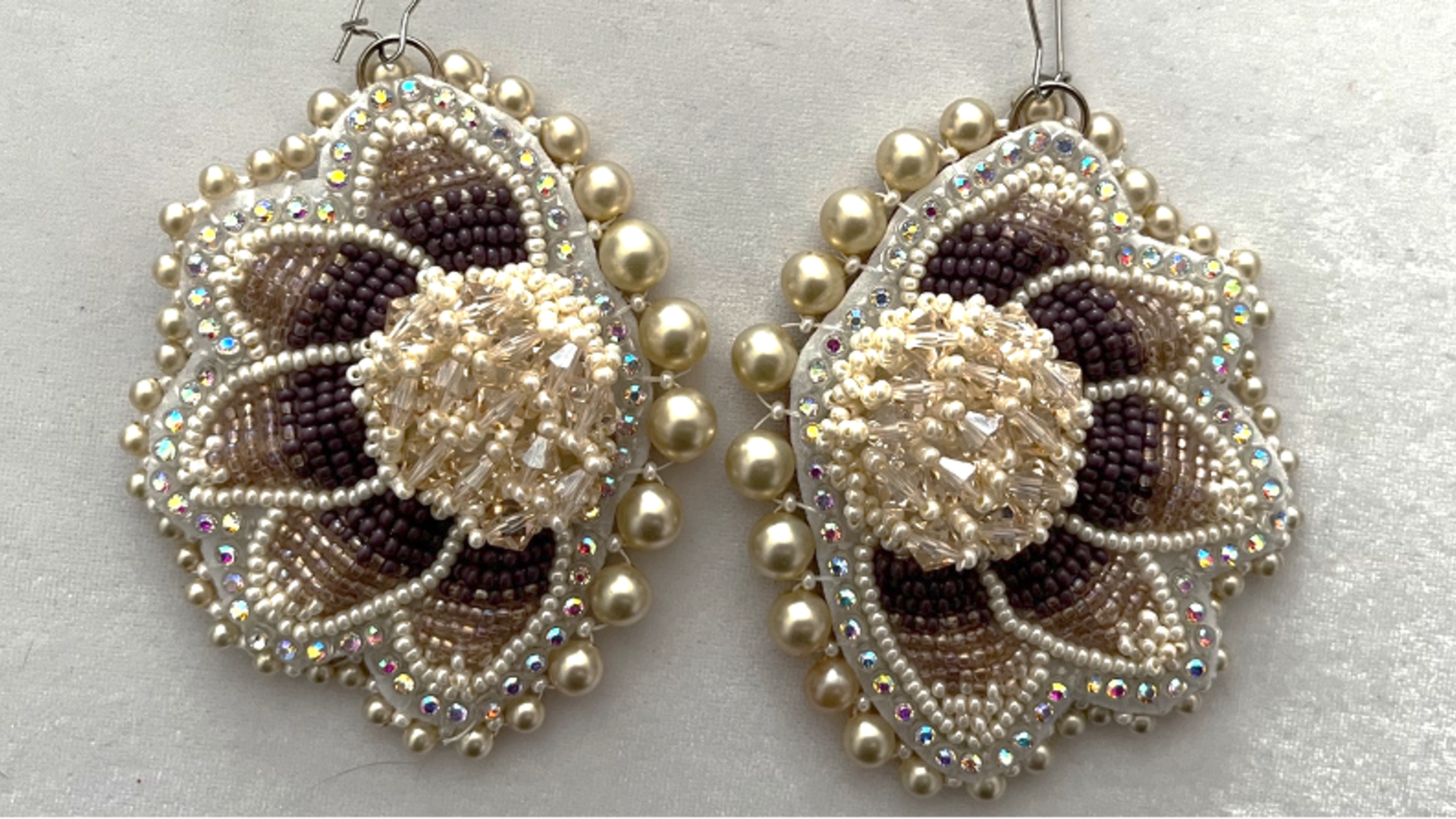 A pair of earrings made of ivory pearls and light brown and dark brown beads made by University of Waterloo historian and anthropologist Talena Atfield who is a member of the Kanien’kehá:ka Nation of the Six Nations of the Grand River.