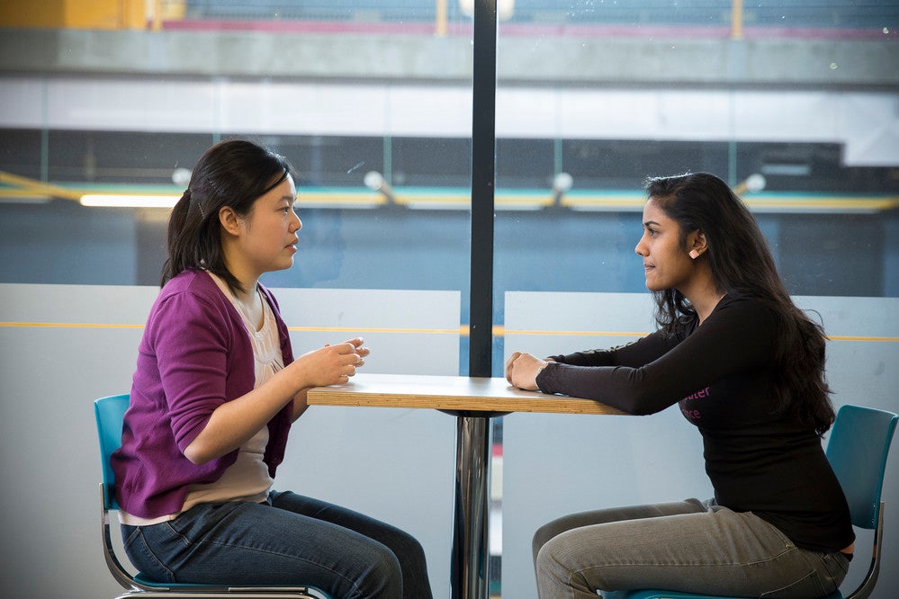 students sitting at a table in conversation