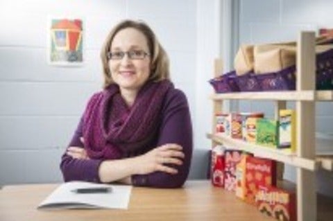 Dr. O'Neill sitting at table with toy shelves beside her