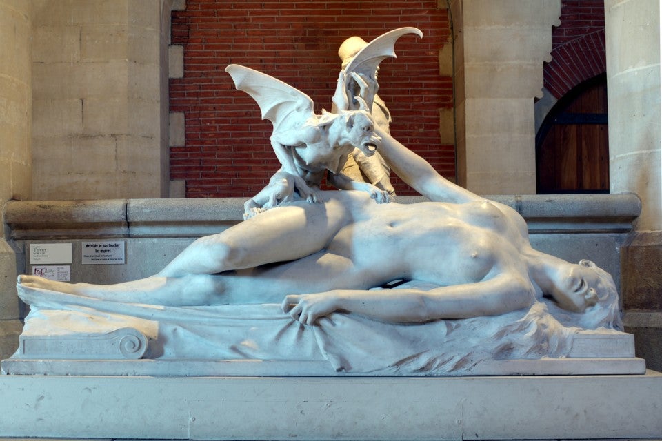 statue of gargoyle attacking sleeping female