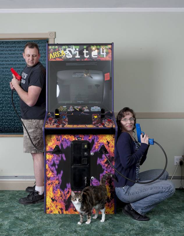 Joe and Carrie posing next to arcade game