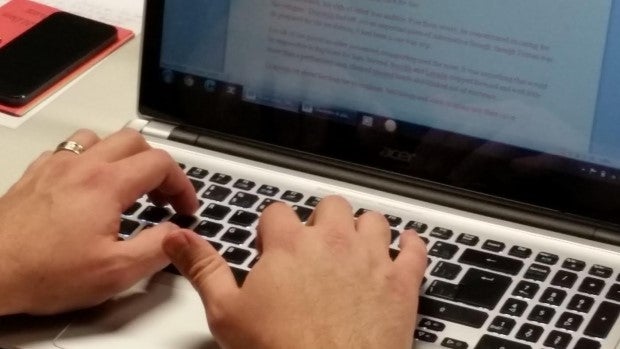 two hands typing on computer keyboard