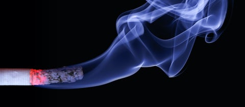 Cigarette with smoke on black background