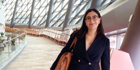 Helena Godinho Nascimento smiling on conference walkway.