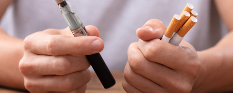 Person holding vape And tobacco cigarette
