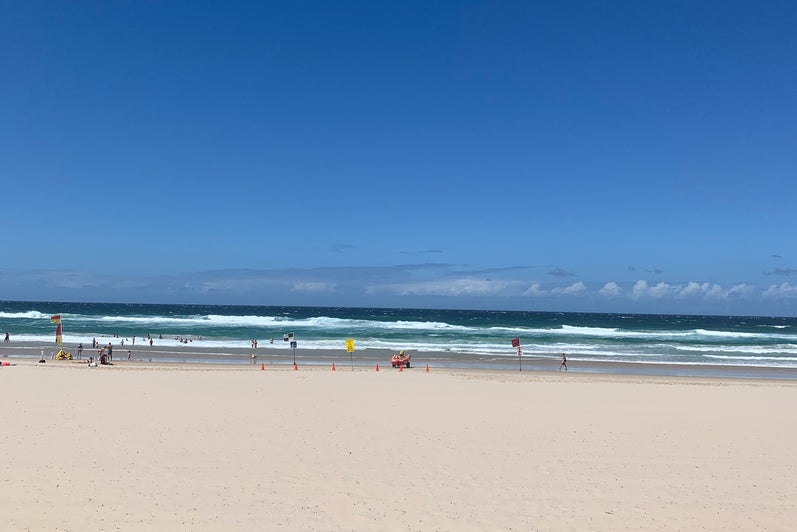 White sand beach blue sky and ocean surf.