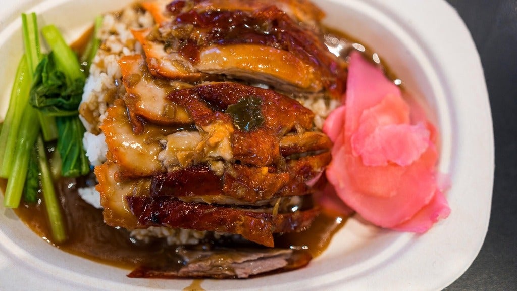 Roasted bbq duck with gravy sauce on top of rice.