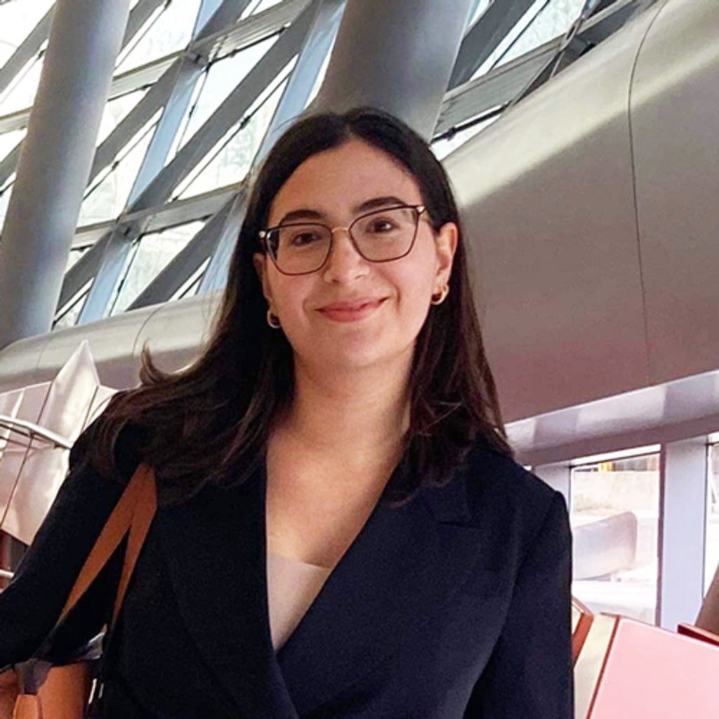 Helena Godinho Nascimento smiling on conference walkway.