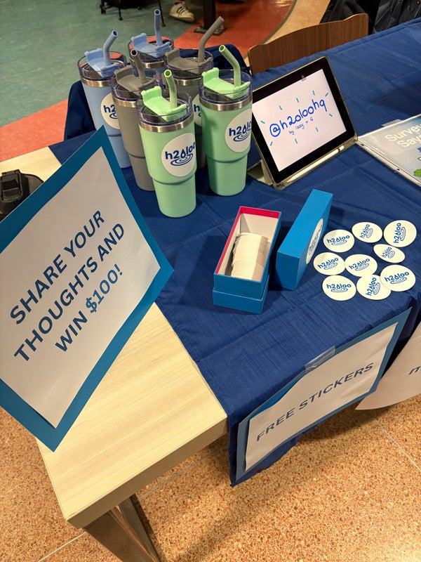 Table display with giveaways and share your thoughts to win sign.