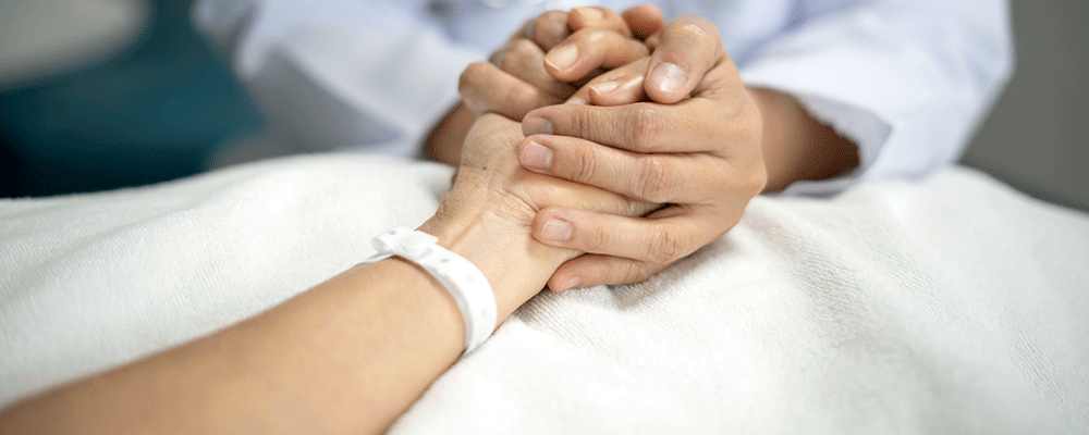 Physician holds patient's hands.