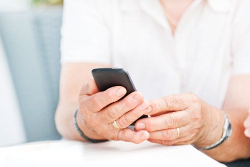 Close-up of senior's hands holding a smartphone