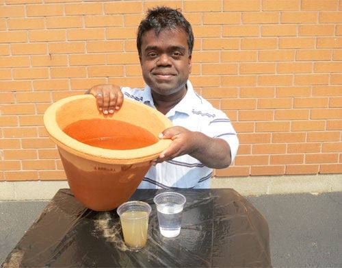 Timothy Muttoo holds the clay water filter he designed.