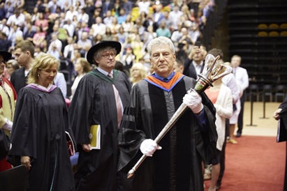 Frank carries the University mace in the Spring 2016 convocation