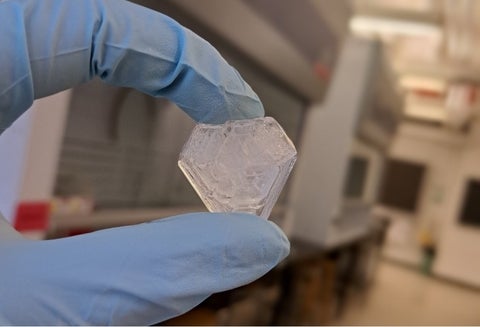 Large clear crystal held in gloved hand