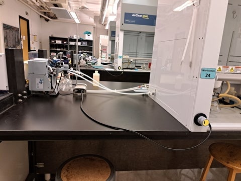 Vacuum pump on laboratory bench. It is connected with plastic tubing to the fume hoods.
