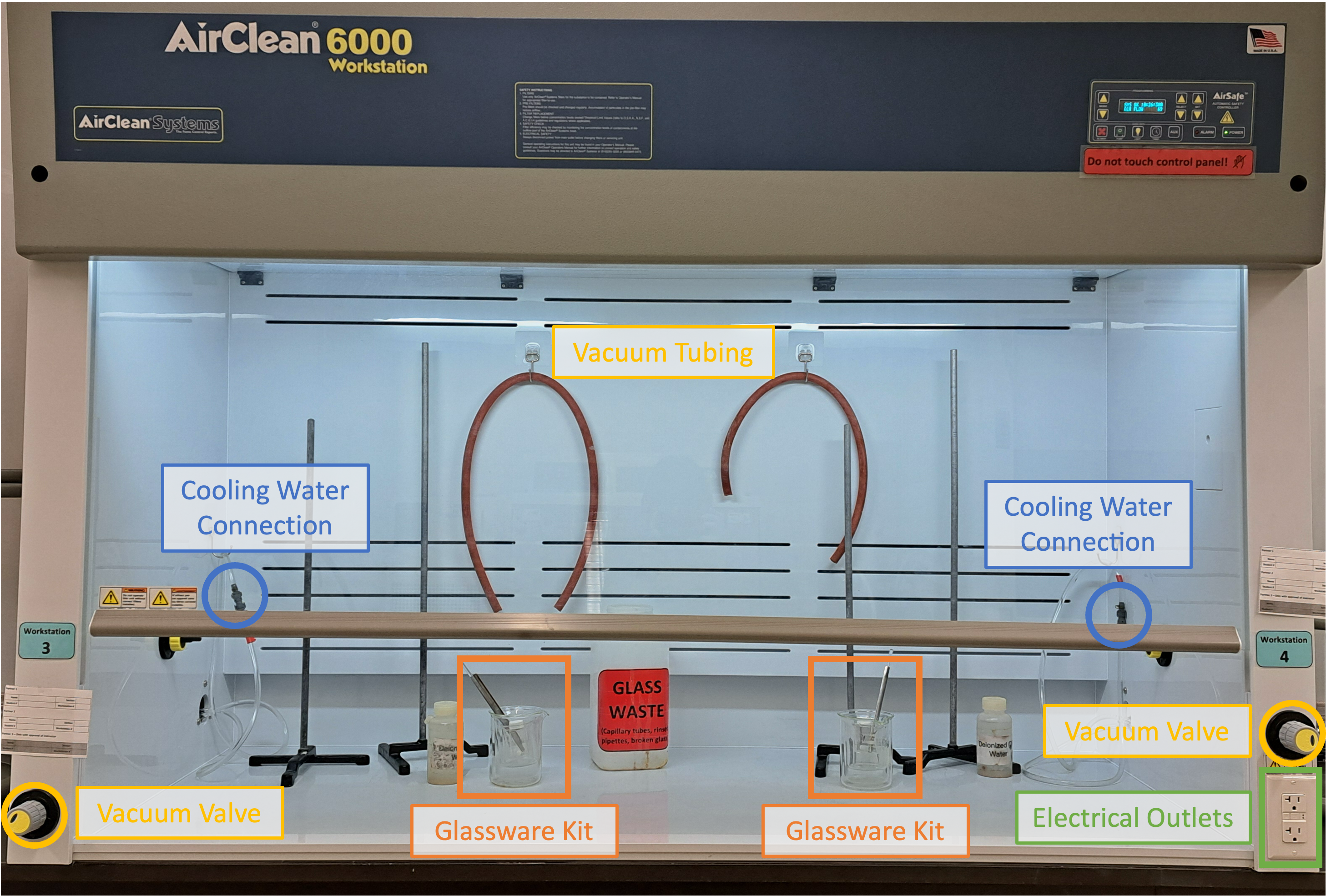 Fume hood in chemistry laboratory. Inside the fume hood there are four retort stands, two vacuum lines and two beaker stacks. Two groups can work in the fume hood.