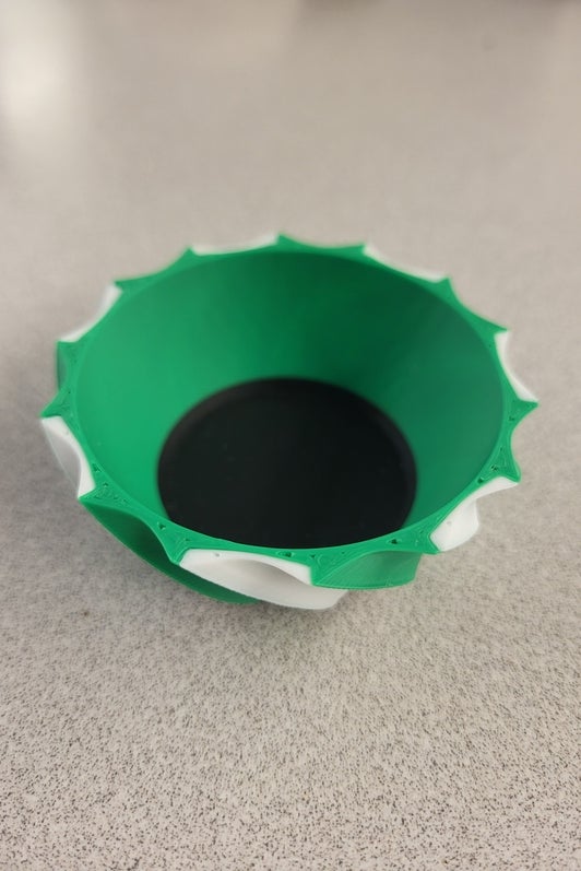 small multicoloured 3d printed dish made using green, white, and black filament