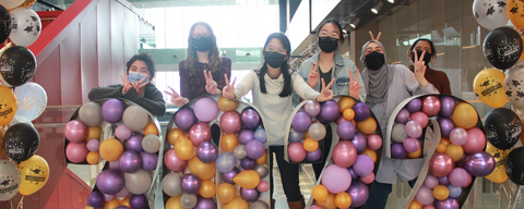 Six graduates posing with a 2022 ballon decoration