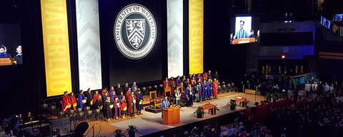 Faculty members in regalia on convocation stage.