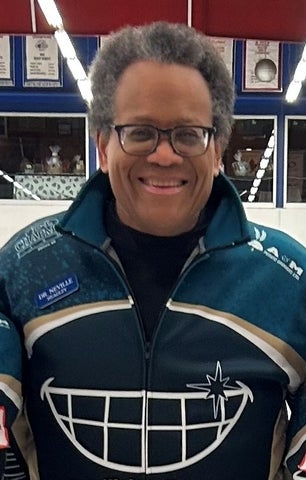 man with a big smile and glasses wearing a jacket with a toothy smile