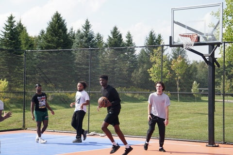 four students playing basketball 