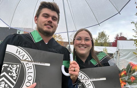 Paige Martin and husband wearing graduation robes and showing diplomas.