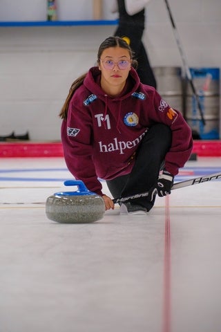 Woman throwing a curling stone.