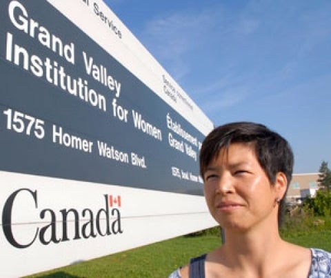 Susan Arai with Grand Valley Institution for Women sign.