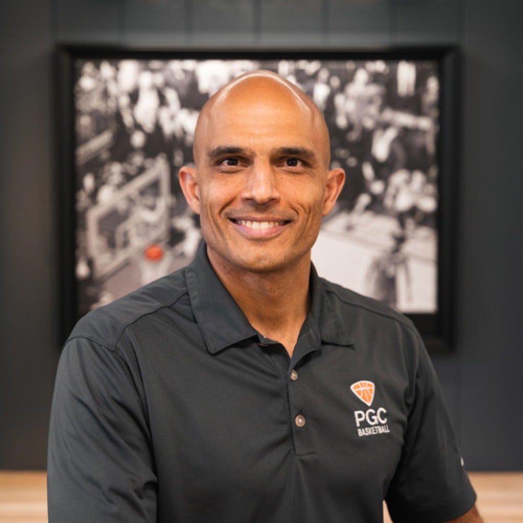 Mano Watsa wearing PGC Basketball shirt in front of photo of him playing.