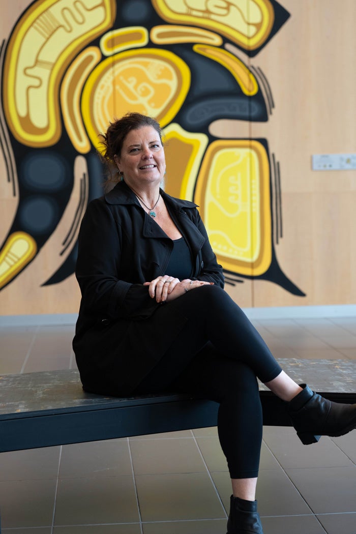 Dale Bellaire, seated in front of Indigenous Waterloo Warrior mural.