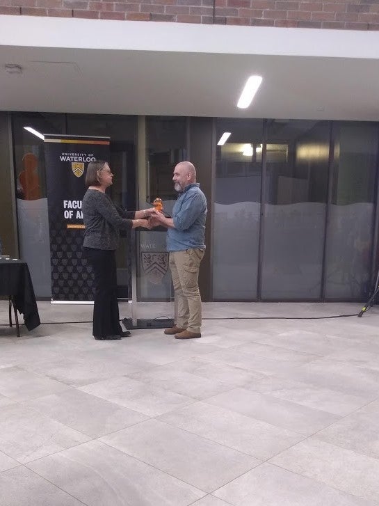 Doug Cowan shakes hands and accepts award