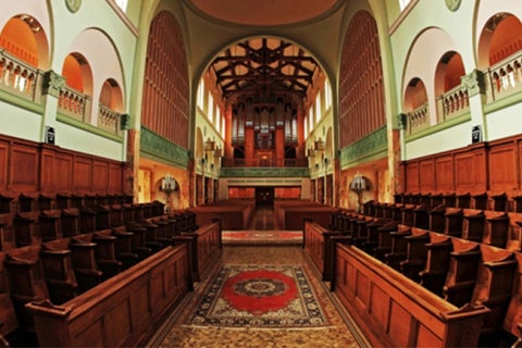The interior of a historic cathedral with a domed ceiling and dark wood trim