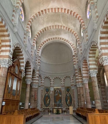 The interior of Etienne Church featuring vaulted ceilings and archways, all decorated in brown and white striped brick