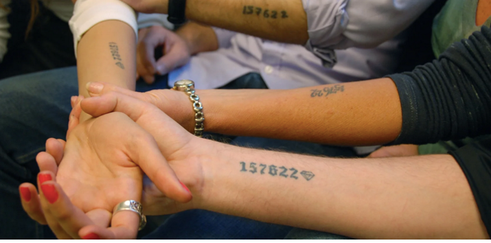 Four arms with commemorative Holocaust tattoos