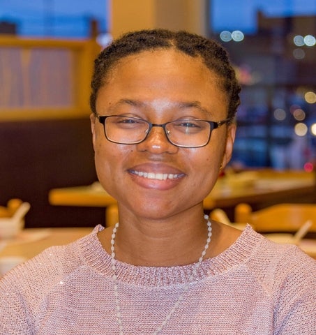 Dr. Grace Gomashie smiling, wearing a pink sweater and white necklace