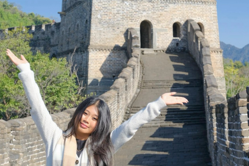 student posing on the great wall of china 