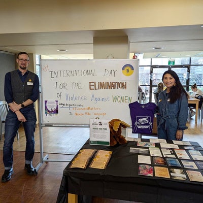 Two people smiling at a booth.